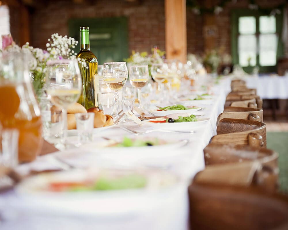 A long banquet table set with glasses and flowers
