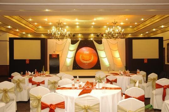 A hall set with tables and chairs for a corporate event