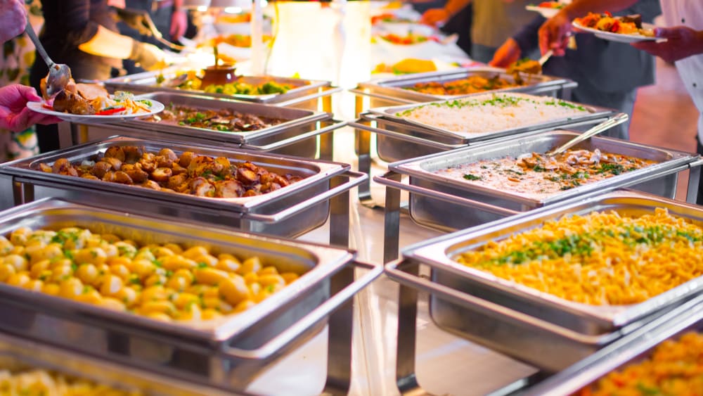 Buffet trays of Indian food at a catered event