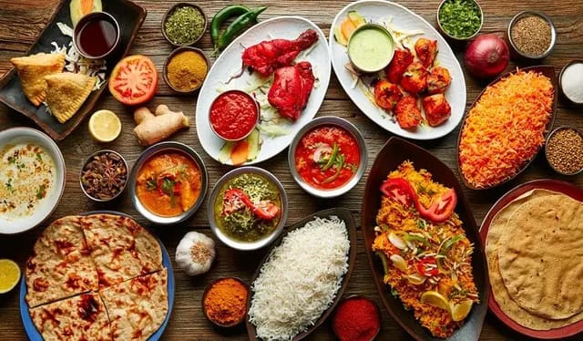 A table spread with tandoori dishes, rice and curries