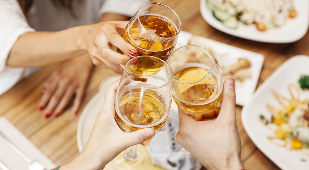Friends toasting with drinks at a restaurant table