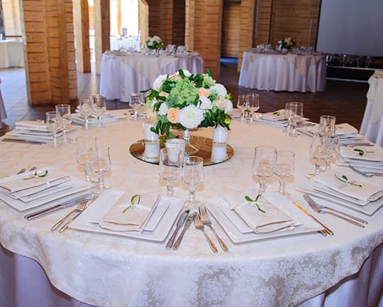 Round tables set with white linen and flowers for an event
